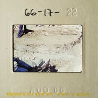 This photo shows an archaeological site with a person standing by, and there's a brick structure visible.