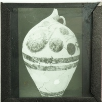 Old vase with patterned design and visible cracks.