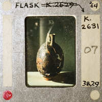 A photograph of a damaged shell on a filmstrip with handwritten notes.