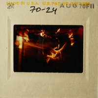 This is an old slide showing a blurry photograph of a person holding a camera.