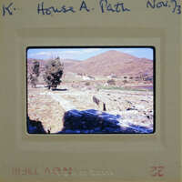 A photograph of a historical site with ruins and mountains in the background, taken on November 7, 1987.