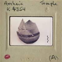 This is an image of a broken pottery artifact with visible layers and cracks, photographed against a white background.