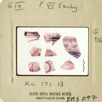 Photograph of fragmented ancient pottery with markings and designs.