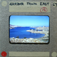 A vintage film strip with a scenic harbor image and handwritten notes on the border.