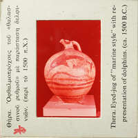 Ancient Greek vase with marine motifs and red-figure style, displayed on a stand.