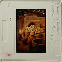 Old pottery displayed in an underground setting, possibly a storage area or museum exhibit.