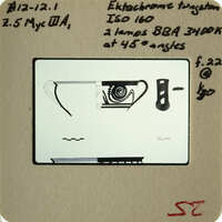 This is an old photograph of a camera with its parts displayed, possibly used for educational purposes.