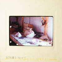 A cat sitting on a table in a workshop.