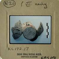 Old ceramic objects displayed on a white surface with visible age and wear.