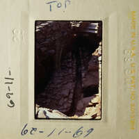 The photo shows an archaeological site with stone ruins, taken from a high angle.