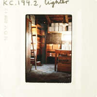 The photo shows an empty room with wooden shelves and boxes, taken from a low angle.