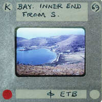 A vintage film strip with a photograph of a scenic landscape featuring mountains and water.