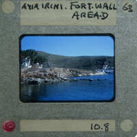 A vintage film strip with a picture of a coastal landscape, including water and hills.