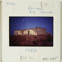 Old building with tiled roof on hillside.