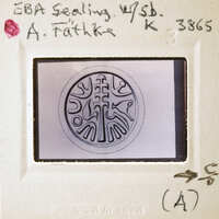 A close-up image of a circular design with intricate patterns, possibly a seal or emblem, displayed on a transparent surface and surrounded by a white border with annotations.