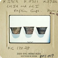 Three ancient cups on display, possibly from a museum exhibit.