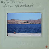 A vintage postcard featuring a scenic view of a body of water, possibly an ocean or sea, with mountains in the background and a pier extending into the water.