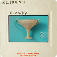 Ancient Greek ceramic cup with handle and two handles on white background.