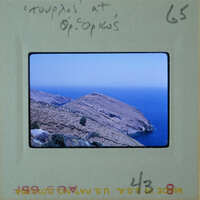 A photograph of a coastal landscape with rocky cliffs and blue ocean waters.
