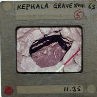 A hole surrounded by stones, with burial remains at the bottom.