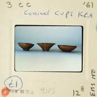 Three brown ceramic cups on a white background.