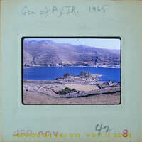 A coastal landscape with a body of water and mountains in the background.