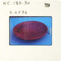 Purple bowl with speckled texture on blue surface.