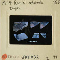 A photo of broken pottery pieces with an overlaid label indicating "Duplicate" and dated 1965.