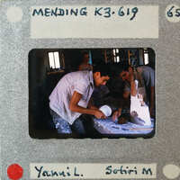 Two men working on a cake, with film strip and photographer's name visible.