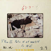 This is an old photograph showing ruins with exposed stone and dirt, possibly from an archaeological site.