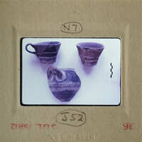 Broken ceramic pieces on display, including cups and bowls.