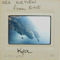 Aerial photograph of a coastline with mountains and water, labeled "KEA AIR VIEW" and the name "ENE".