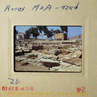 The photo shows an archaeological site with stone ruins, and there is a sign indicating "Areas Maa - Road."