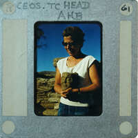 Woman holding a terracotta head, smiling at the camera.