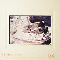 This photo shows an archaeological site with stone ruins and a person standing near them.