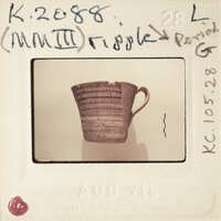 A photograph of a broken clay mug with a handle, taken against a white background.