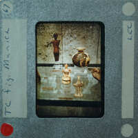 Image of a museum display with ancient artifacts, including vases and figurines, on film clapperboard.