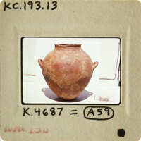 Ancient clay pot with markings on display.