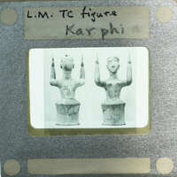 A black and white photograph of two ancient Greek vases with a label reading "LM TC Figure Karpoi".