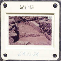 A photograph showing an excavation site with exposed layers and rock formations, possibly from an archaeological dig.