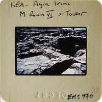 Ruined stone structure with vegetation, possibly part of an ancient city.