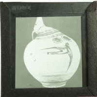 Image of an antique vase with bird flying to the right.