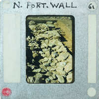 Old photograph of rock wall on film strip with label "N. Fort Wall".