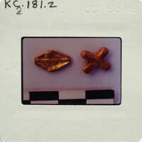 Two gold color metallic pieces; one bead shaped and one X-shaped.