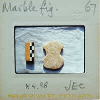 A small marble figurine next to a scale.