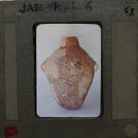 A slide of a broken clay pot with visible cracks and missing pieces.