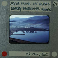 Photo of a misty landscape with mountains and water, displayed on an old-fashioned film strip.