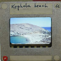 A slide of a rocky coastline with blue waters and a small lagoon.