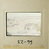 The photo shows an old cityscape with a prominent building and ruins, taken from a distance.