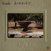 Ancient pottery on wooden table with trees in background.
